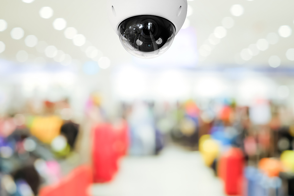 Modern public CCTV camera with blur interior shopping mall backg